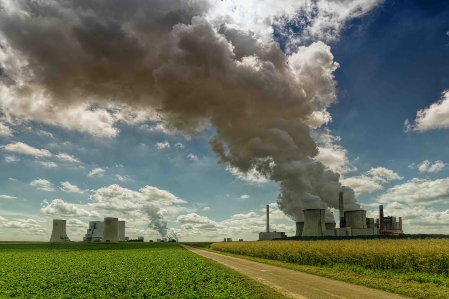 Power plant in a field with a large amount of smoke coming out of the plant
