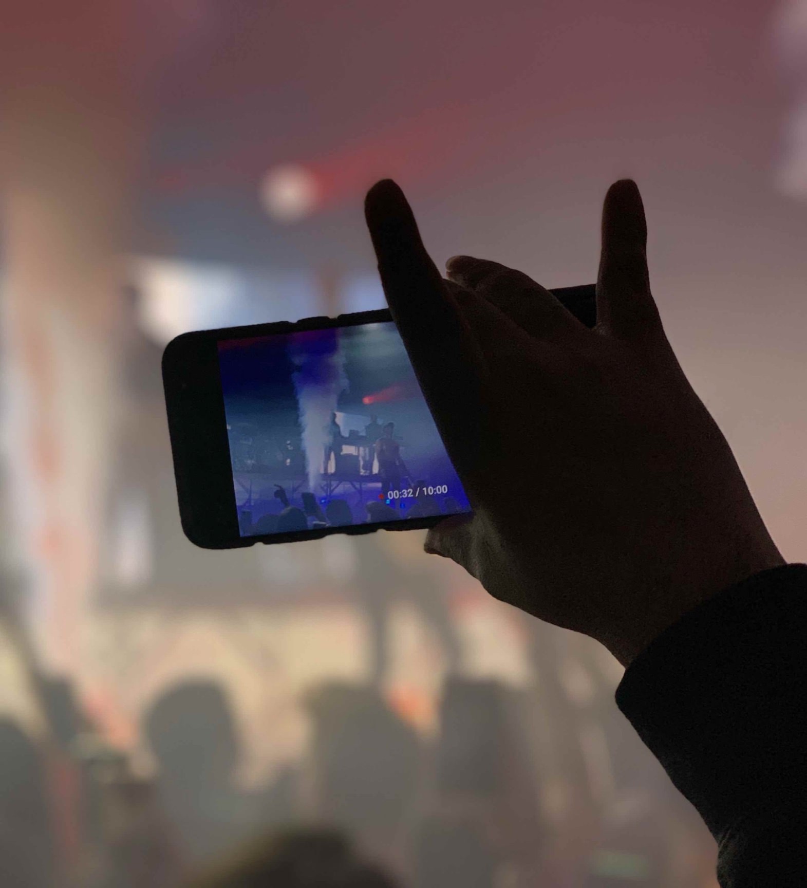 Person capturing video of a live concert with mobile phone