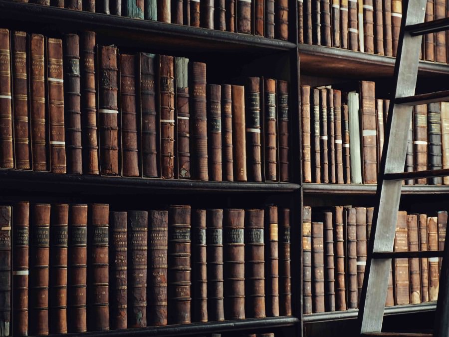 Three library shelves with full of historic looking books